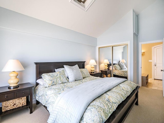 carpeted bedroom with a closet and lofted ceiling