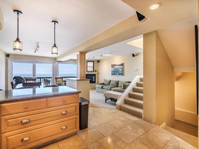 kitchen featuring decorative light fixtures, track lighting, and a water view