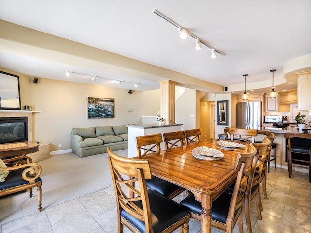 carpeted dining room featuring a tiled fireplace