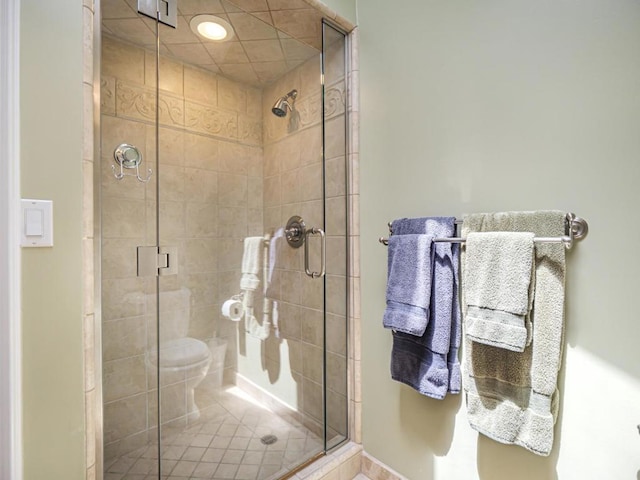 bathroom featuring toilet and a shower with door