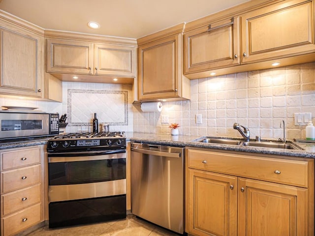 kitchen featuring sink, backsplash, appliances with stainless steel finishes, and dark stone countertops