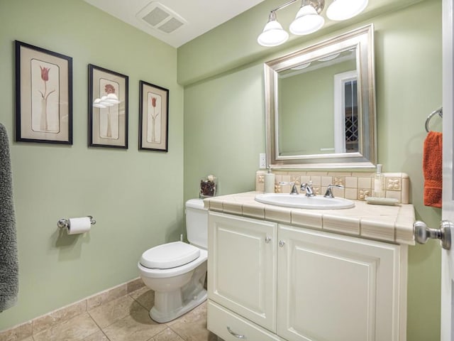 bathroom with toilet, tile patterned flooring, decorative backsplash, and vanity