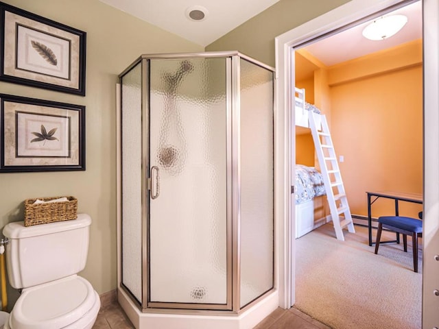 bathroom featuring toilet, tile patterned flooring, and an enclosed shower