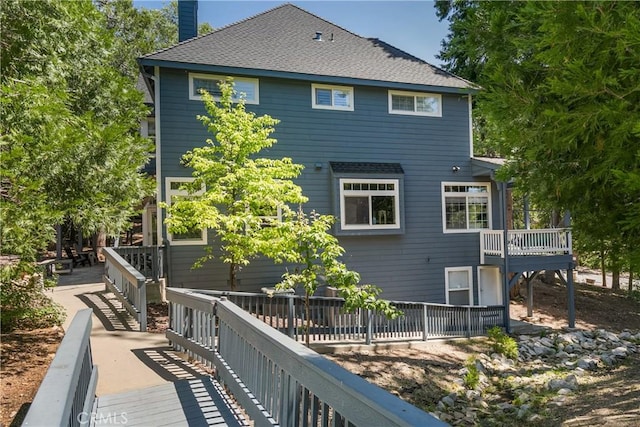 rear view of property featuring a wooden deck