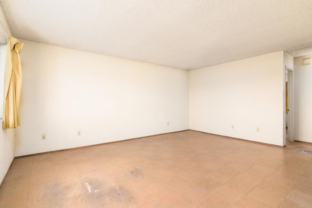 empty room with wood-type flooring and a textured ceiling