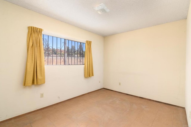 unfurnished room featuring a textured ceiling