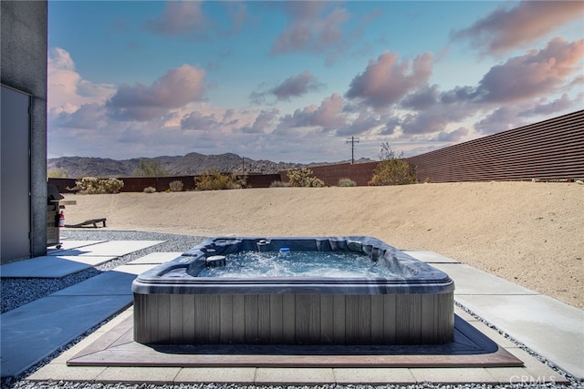 view of patio with a mountain view and a hot tub