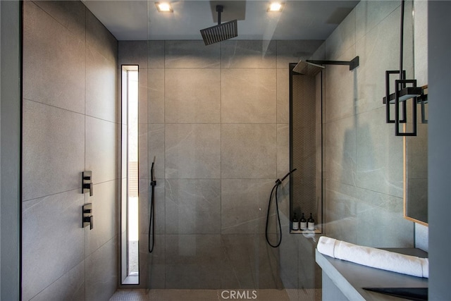 bathroom with a tile shower and tile walls