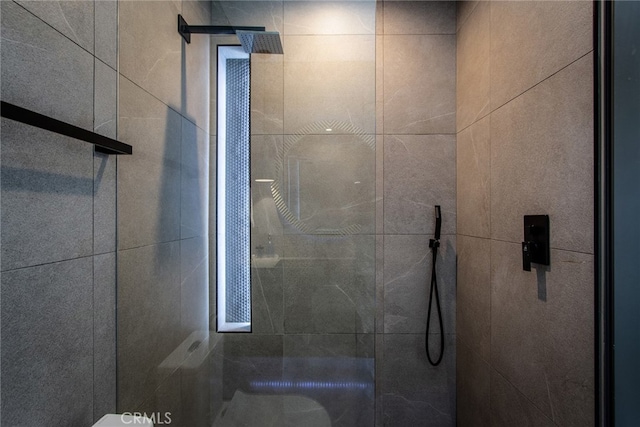 bathroom with toilet and tiled shower