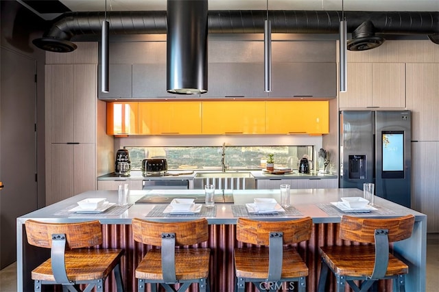 kitchen with a kitchen breakfast bar, stainless steel fridge, and sink