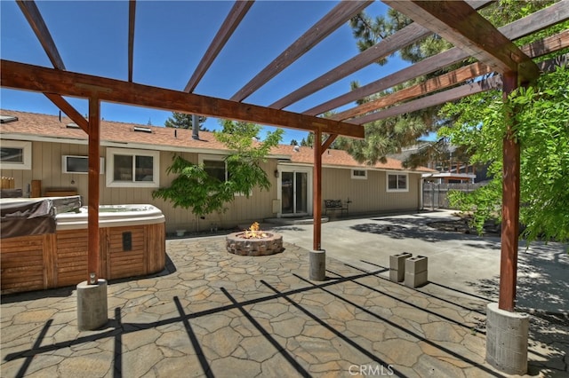 view of patio with a hot tub, a pergola, and a fire pit