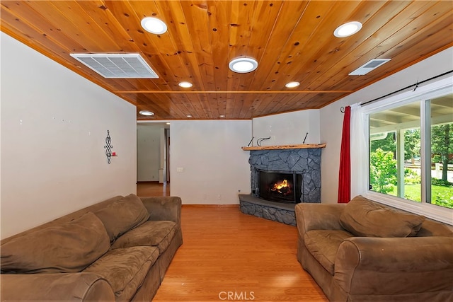 living room featuring wood ceiling, a fireplace, and light hardwood / wood-style flooring