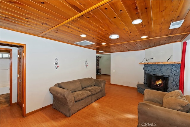 living room featuring a stone fireplace, wood ceiling, and hardwood / wood-style flooring