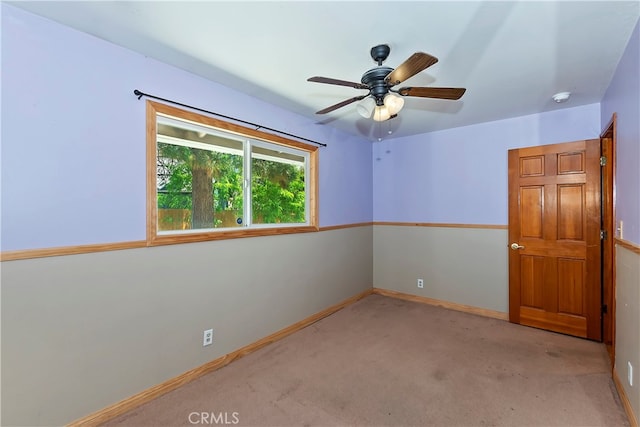 carpeted empty room featuring ceiling fan