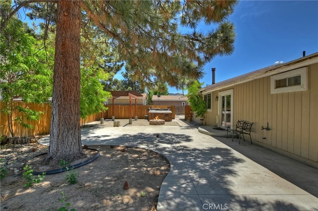 view of yard with a hot tub and a patio area