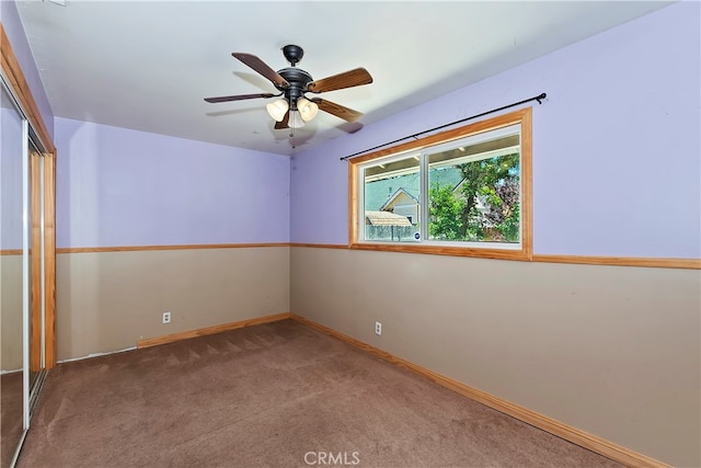 carpeted spare room featuring ceiling fan