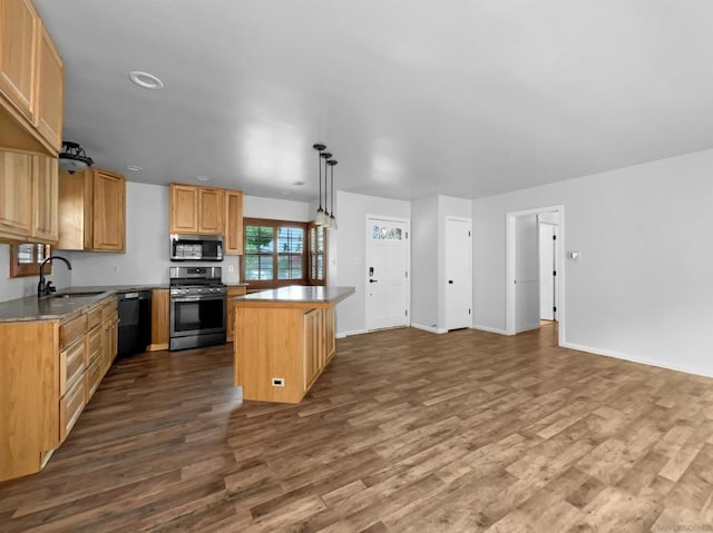 kitchen featuring sink, dark wood-type flooring, pendant lighting, a kitchen island, and appliances with stainless steel finishes