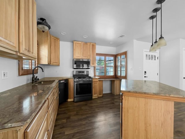 kitchen with a center island, sink, appliances with stainless steel finishes, decorative light fixtures, and dark hardwood / wood-style flooring