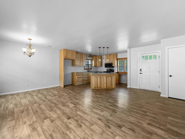 kitchen featuring pendant lighting, a kitchen island, hardwood / wood-style flooring, and a chandelier