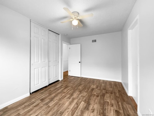 unfurnished bedroom with a closet, ceiling fan, and hardwood / wood-style floors