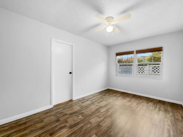 empty room featuring ceiling fan, dark hardwood / wood-style flooring, and a textured ceiling