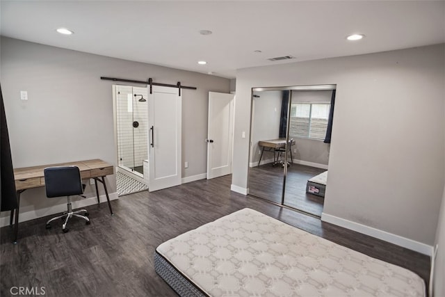 office with a barn door and dark wood-type flooring