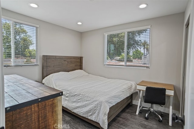 bedroom with dark hardwood / wood-style flooring and multiple windows