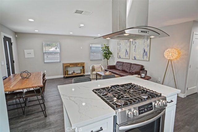 kitchen with island range hood, white cabinetry, light stone countertops, and high end stainless steel range