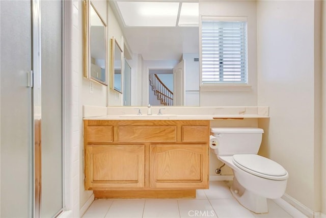 bathroom with toilet, vanity, tile patterned floors, and a shower with shower door