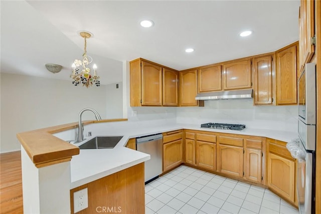 kitchen featuring sink, a notable chandelier, kitchen peninsula, pendant lighting, and appliances with stainless steel finishes