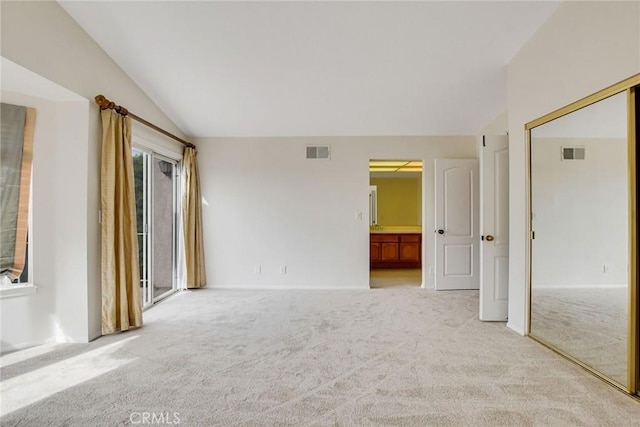 carpeted spare room featuring vaulted ceiling