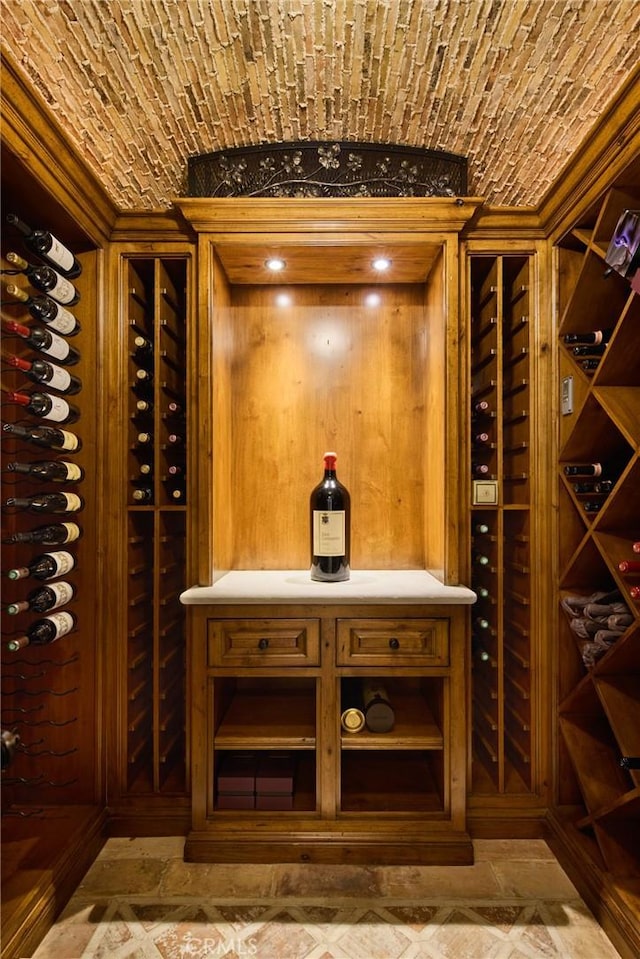 wine area featuring brick ceiling and ornamental molding