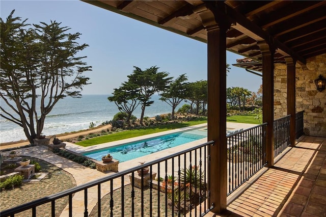 view of swimming pool with a water view and a beach view