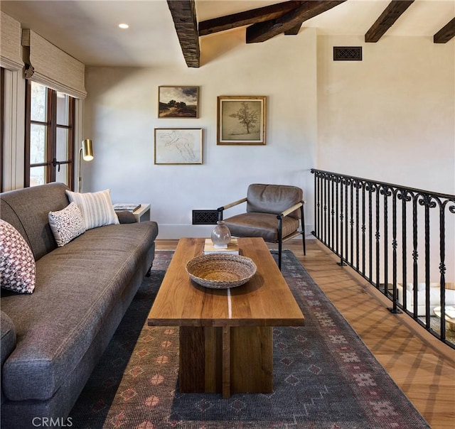 living room with beamed ceiling and dark wood-type flooring