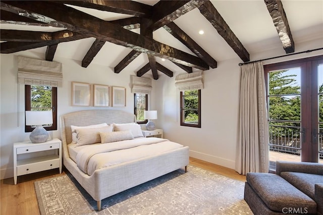 bedroom featuring hardwood / wood-style floors, vaulted ceiling with beams, and access to exterior