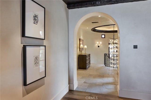 corridor with light hardwood / wood-style floors and an inviting chandelier