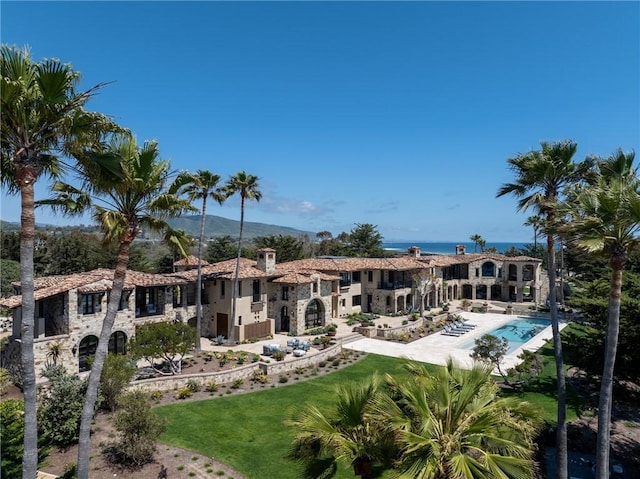 back of property featuring a lawn and a community pool