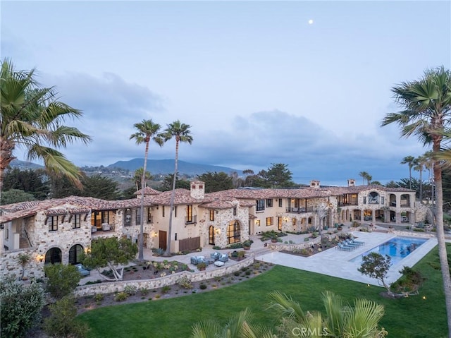 exterior space with a lawn, a mountain view, and a pool