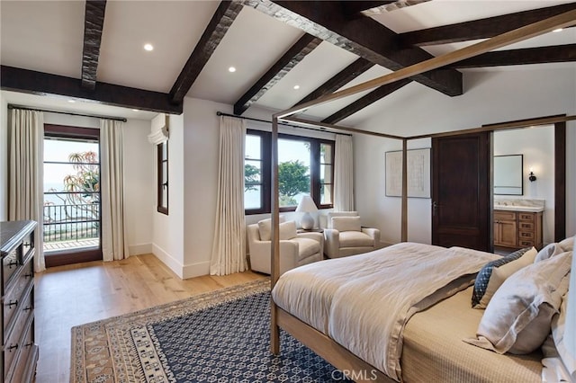 bedroom featuring lofted ceiling with beams, ensuite bathroom, light hardwood / wood-style flooring, and multiple windows