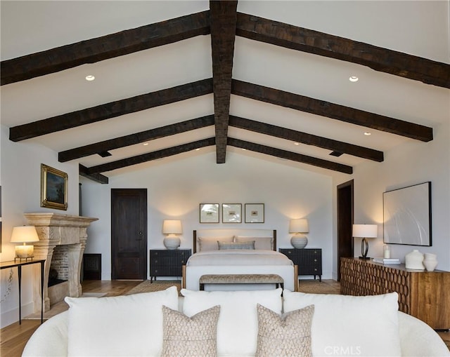 bedroom featuring vaulted ceiling with beams and light wood-type flooring