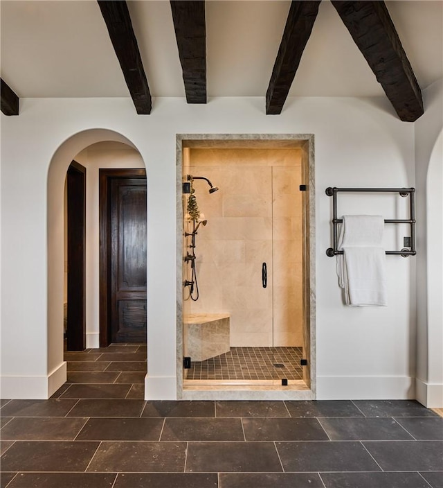 bathroom featuring beamed ceiling and walk in shower