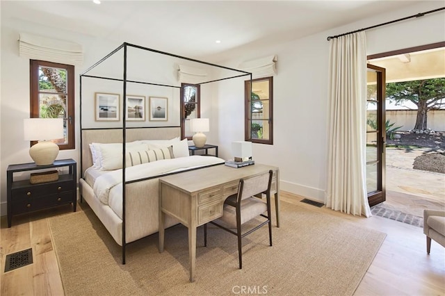 bedroom with access to exterior and light wood-type flooring