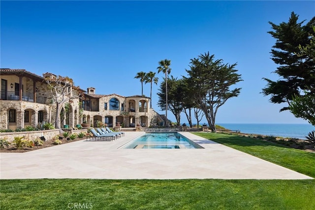 view of pool featuring a patio area, a yard, and a water view