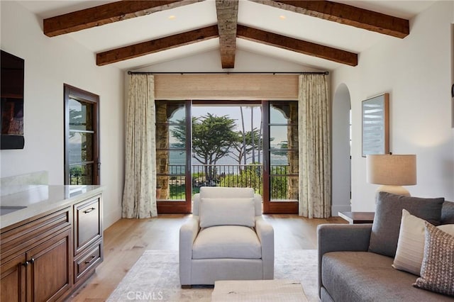 interior space with vaulted ceiling with beams and light hardwood / wood-style flooring