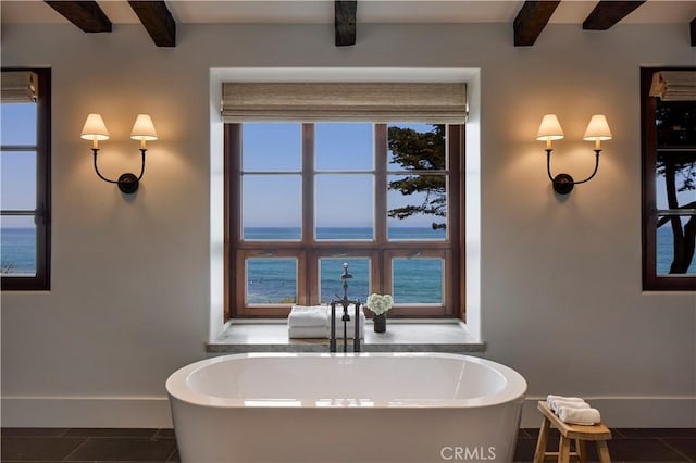 bathroom with beamed ceiling, a water view, and a wealth of natural light