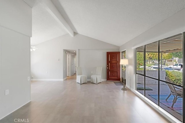 interior space with ceiling fan and lofted ceiling with beams