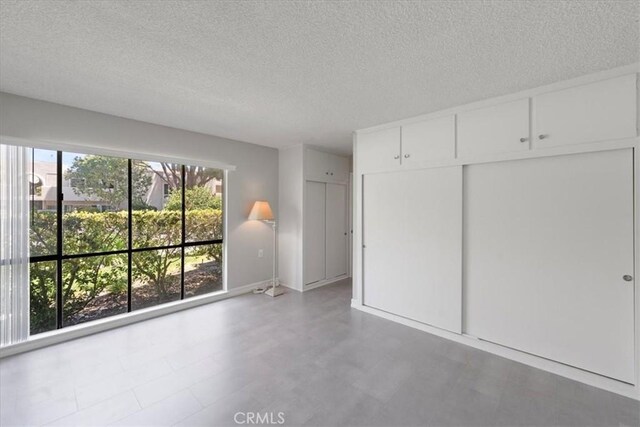 unfurnished bedroom with a textured ceiling and a closet