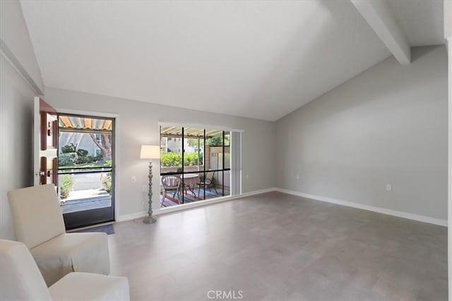 unfurnished living room with a wealth of natural light and lofted ceiling with beams