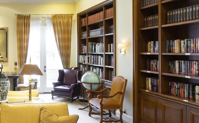 living area with light carpet and ornamental molding