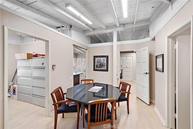 dining room with lofted ceiling with beams, light hardwood / wood-style floors, and wooden ceiling